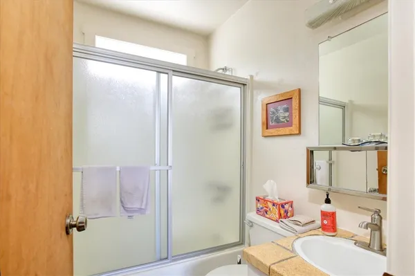 a bathroom with a sink mirror vanity and toilet