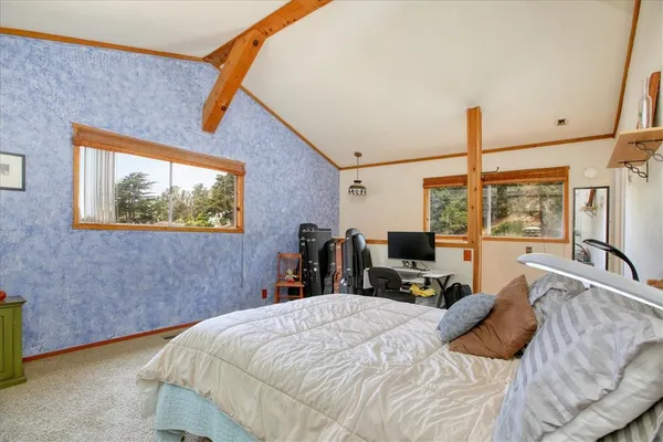 a bed room with a bed and a flat tv screen on the dresser