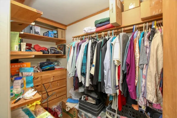 a view of walk in closet with clothes and shoes