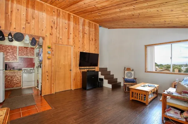 a living room with furniture and a flat screen tv with wooden floor