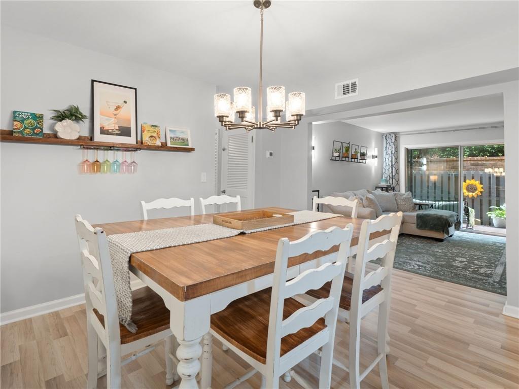 6851 Roswell Road, Unit H26 Atlanta, GA 30328 - Photo 6 of 49 a dining room with furniture a chandelier and wooden floor