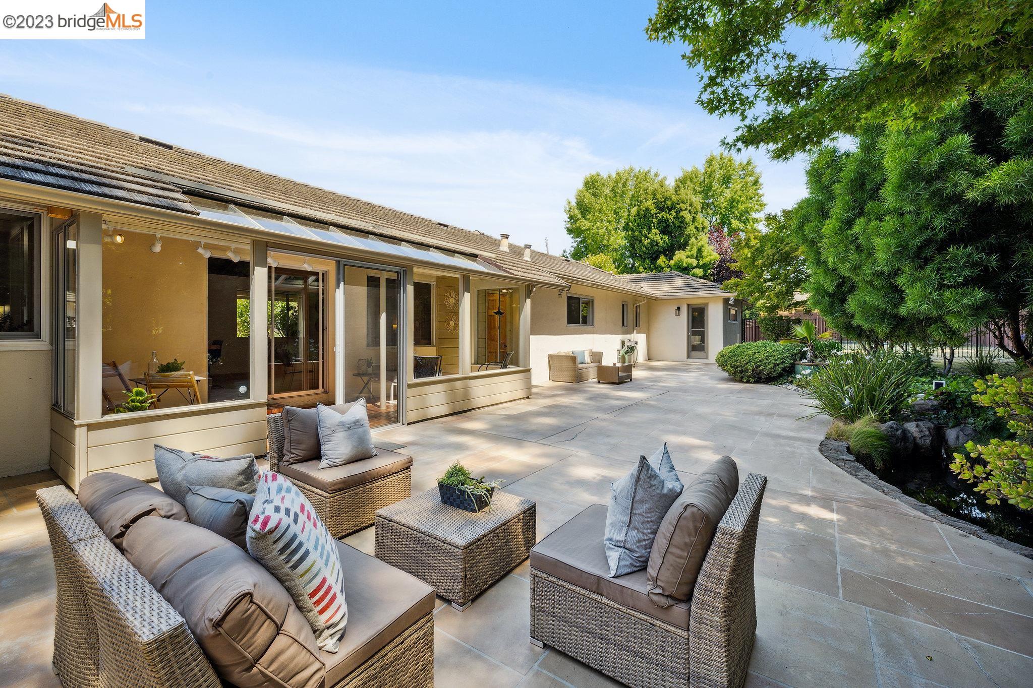 a view of a patio with couches table and chairs and potted plants