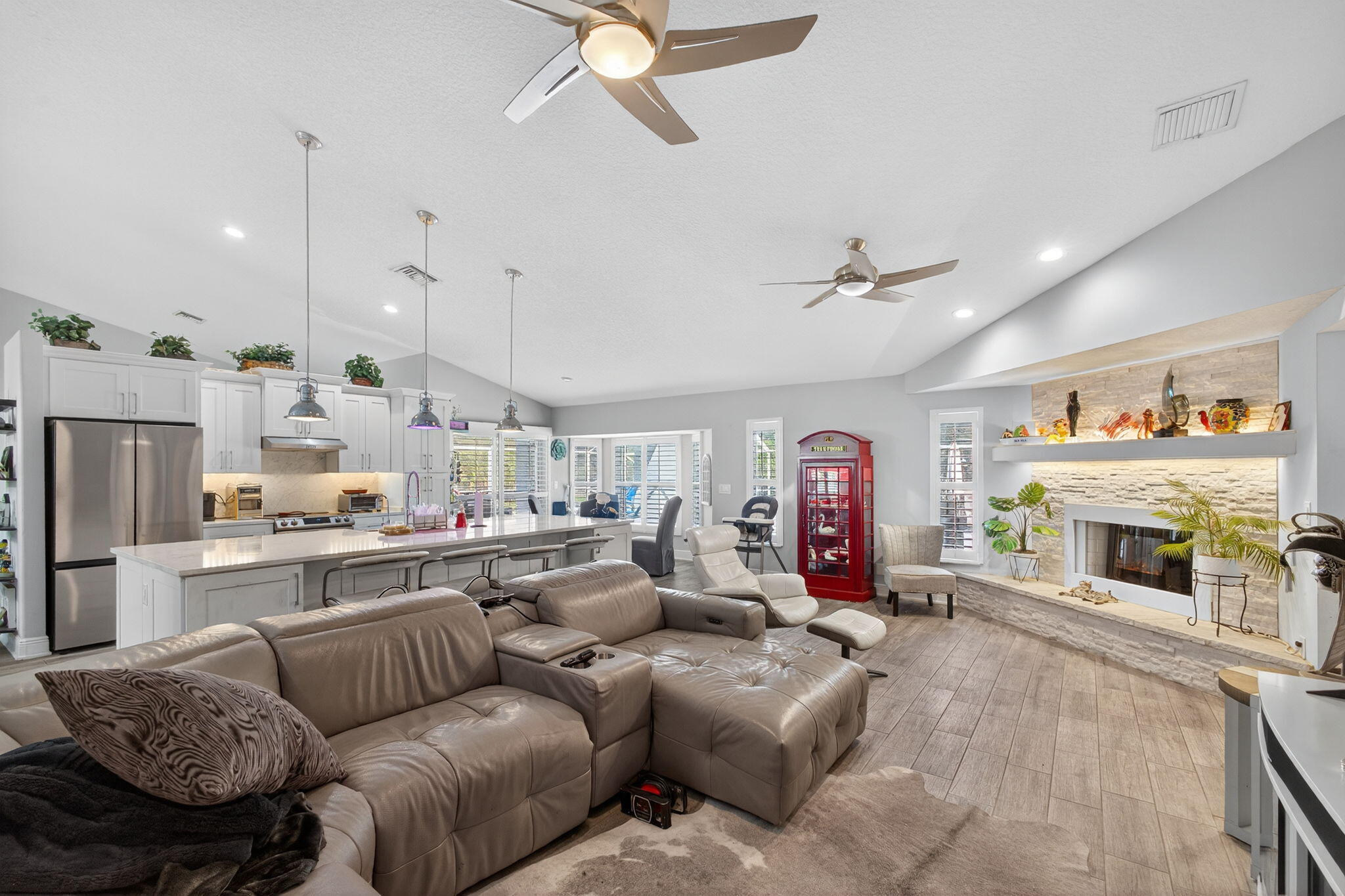 13033 160th Road North Jupiter, FL 33478 - Photo 27 of 79 a living room with furniture kitchen view and a fireplace