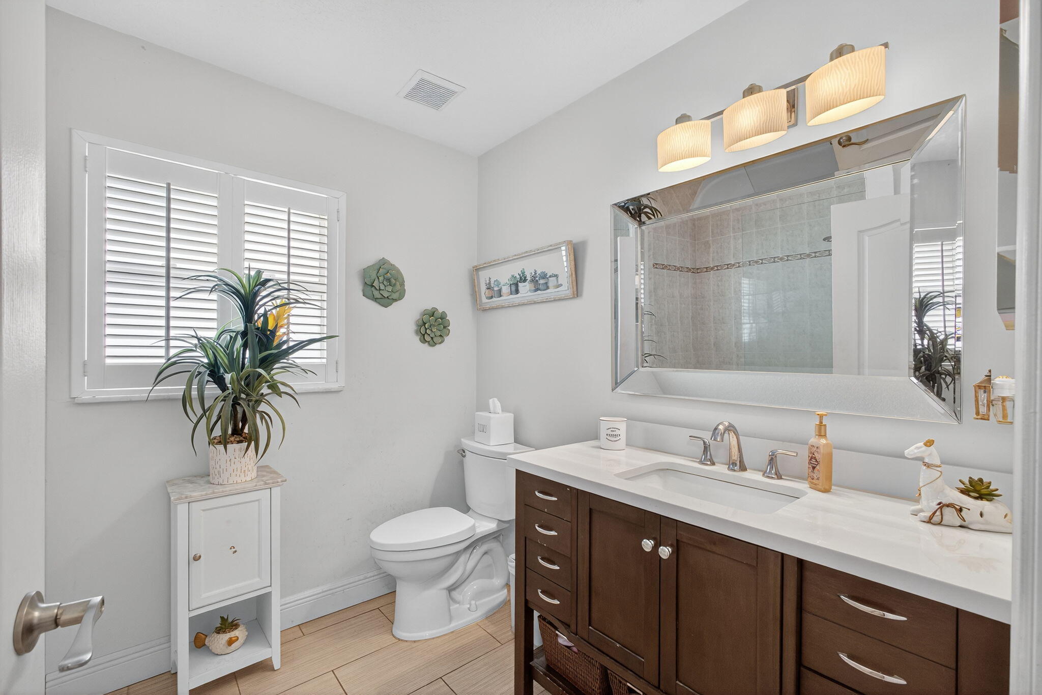13033 160th Road North Jupiter, FL 33478 - Photo 36 of 79 a bathroom with a granite countertop toilet a sink a mirror a window and vanity