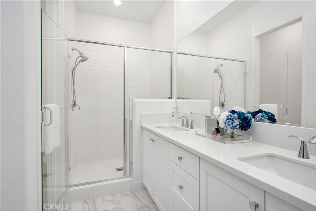 27225 Cranmore Way, Unit 101 Valencia, CA 91381 - Photo 18 of 36 a bathroom with a double vanity sink mirror and shower