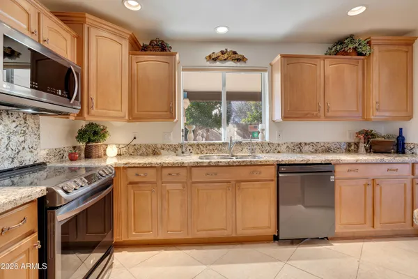 a kitchen with stainless steel appliances granite countertop a sink stove and microwave