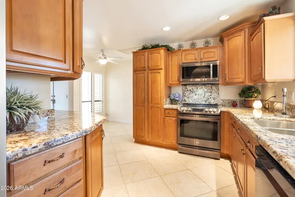 a kitchen with stainless steel appliances granite countertop a stove a sink and a refrigerator