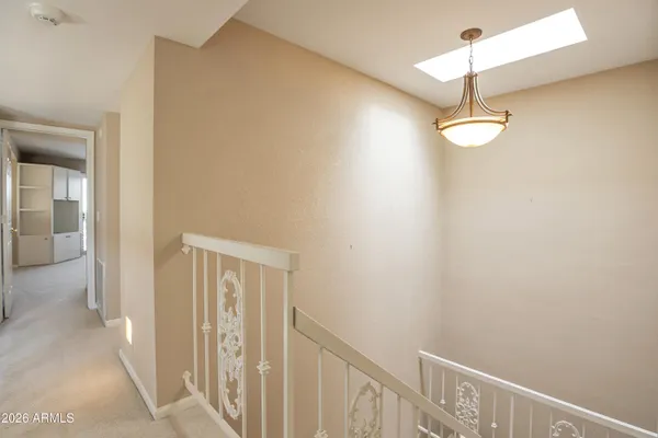 a view of a hallway with a chandelier fan