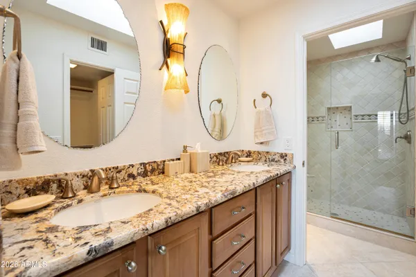 a bathroom with a granite countertop sink and a mirror