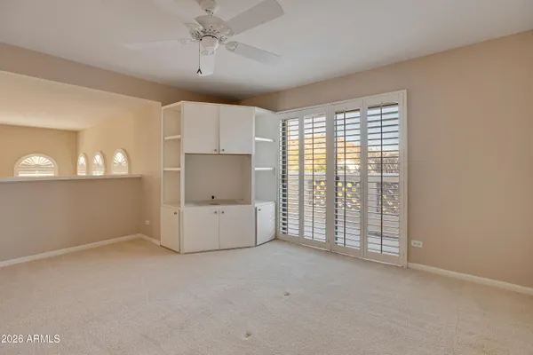 en empty room with windows and ceiling fan