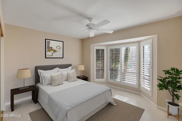 a bedroom with a large bed and a potted plant