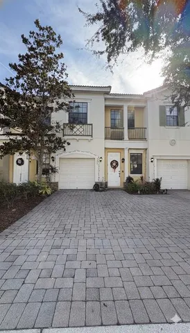 a view of a white house with a yard and large tree