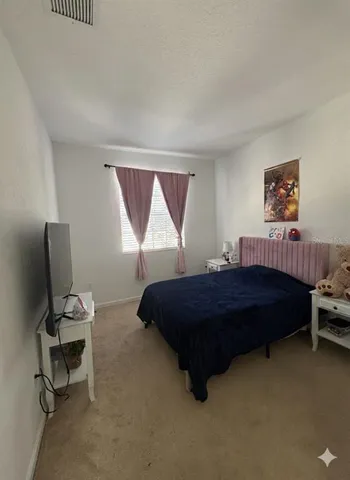 a bedroom with a bed and a potted plant on dresser