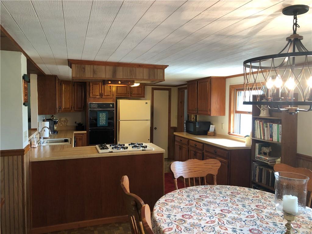 230 Locust Road Addison, PA 15411 - Photo 23 of 43 a kitchen with stainless steel appliances kitchen island granite countertop a sink refrigerator stove dining table and chairs