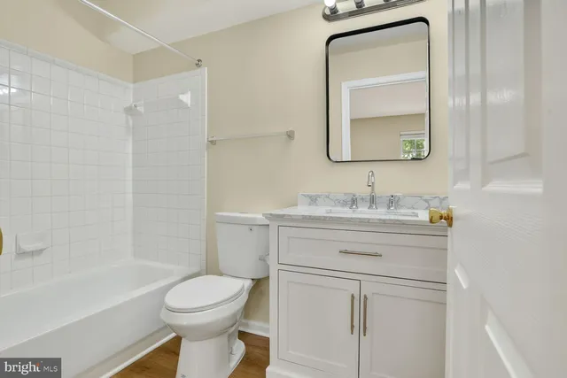 a bathroom with a toilet a sink a vanity and mirror