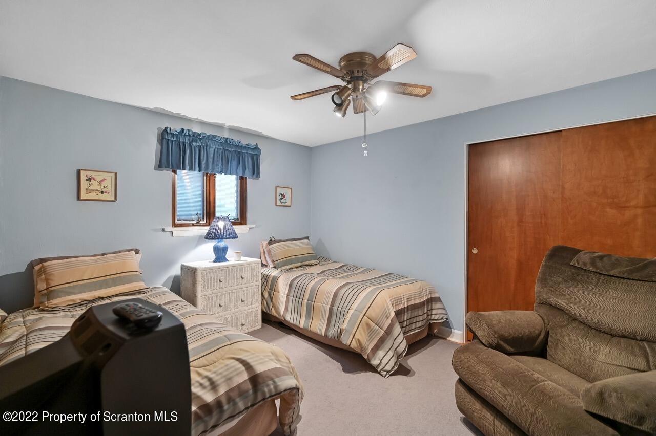 807 Layton Road Clarks Summit, PA 18411 - Photo 49 of 73 a bedroom with two beds and a chandelier