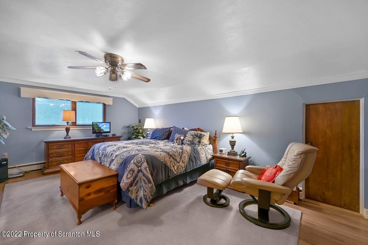 807 Layton Road Clarks Summit, PA 18411 - Photo 54 of 73 a spacious bedroom with a bed and a chandelier