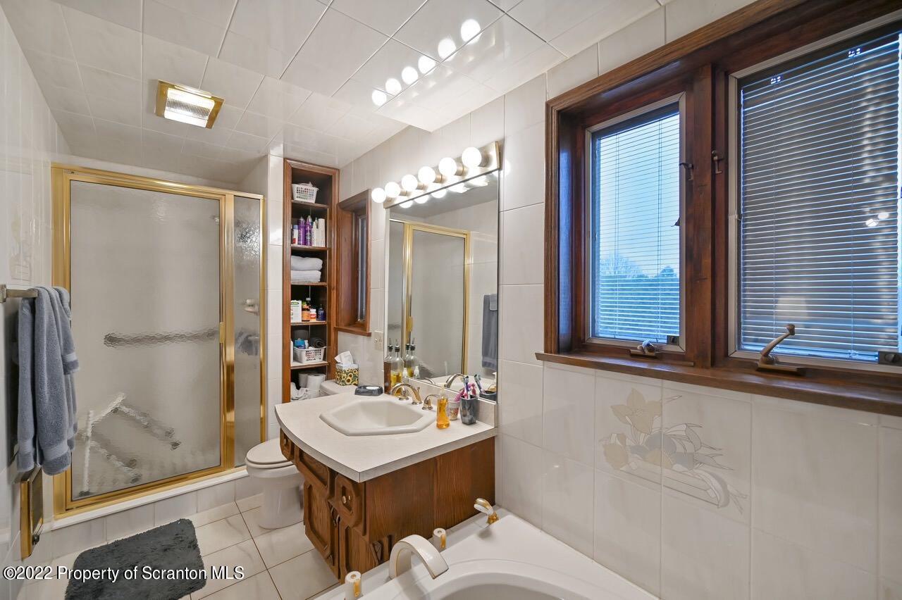 807 Layton Road Clarks Summit, PA 18411 - Photo 59 of 73 a bathroom with a sink a large mirror and a shower