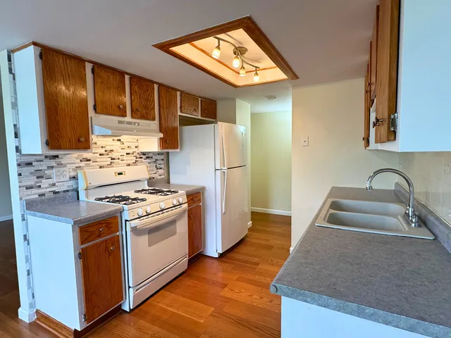 a kitchen with stainless steel appliances granite countertop a sink stove and refrigerator