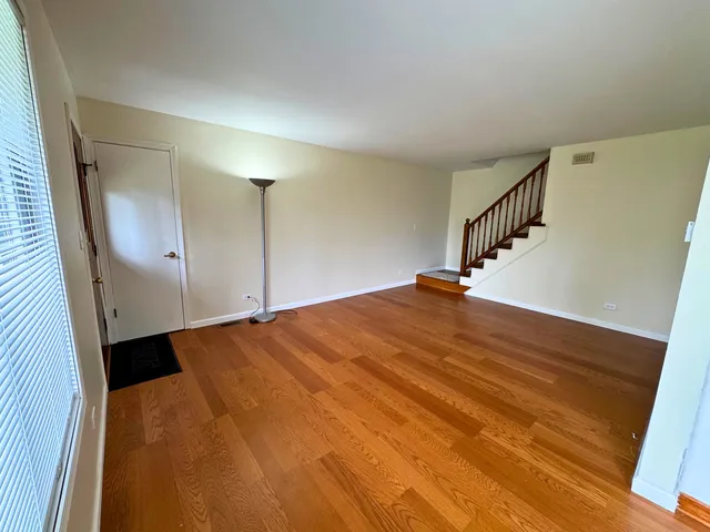 a view of a big room with wooden floor and windows