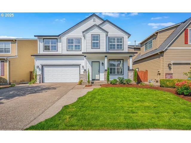 a front view of a house with a yard and garage