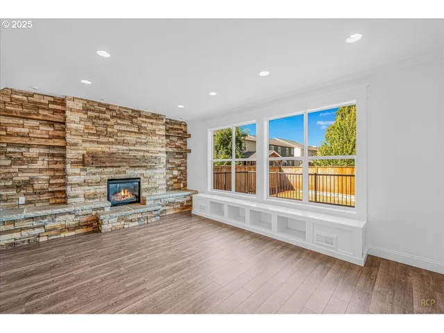 a view of empty room with wooden floor and fireplace