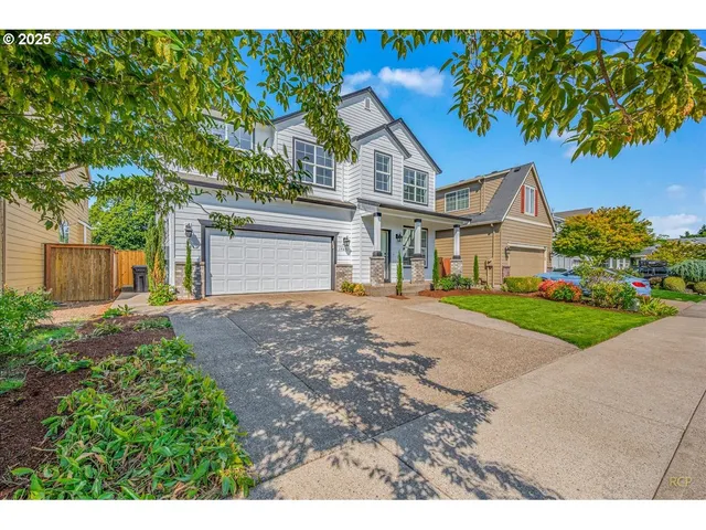 a front view of a house with a yard and a garage