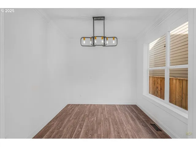 a view of a room with wooden floor and window