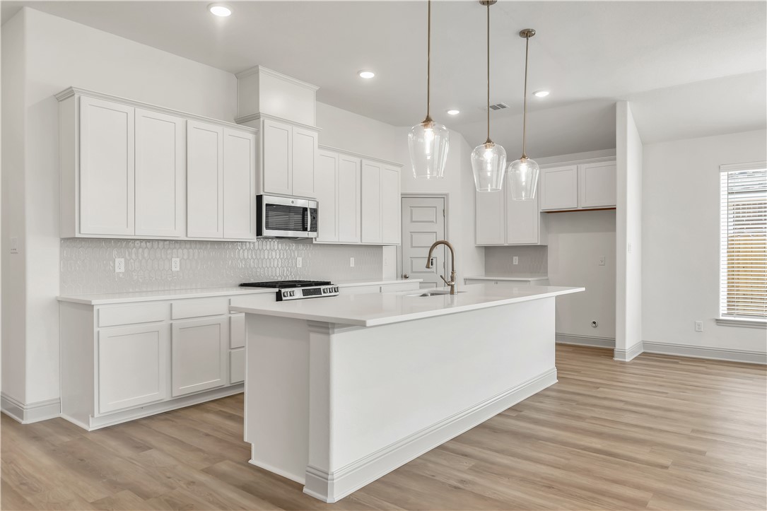 5955 Eldora Drive College Station, TX 77845 - Photo 12 of 36 a large kitchen with kitchen island a sink stainless steel appliances and cabinets