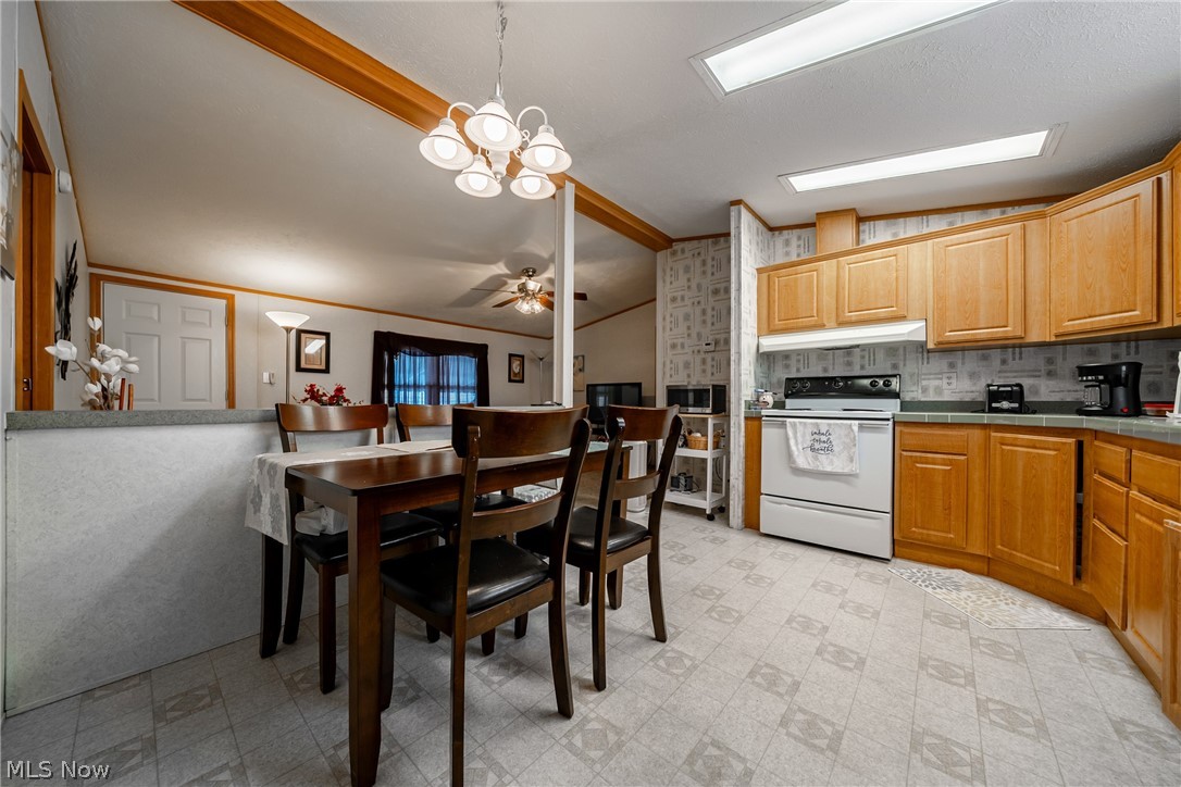 2700 Brookpark Road, Unit 513 Cleveland, OH 44134 - Photo 11 of 25 Kitchen with tile counters, light floors, electric stove, vaulted ceiling with beams, and hanging lights