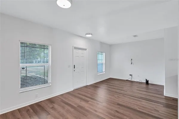 a view of empty room with wooden floor