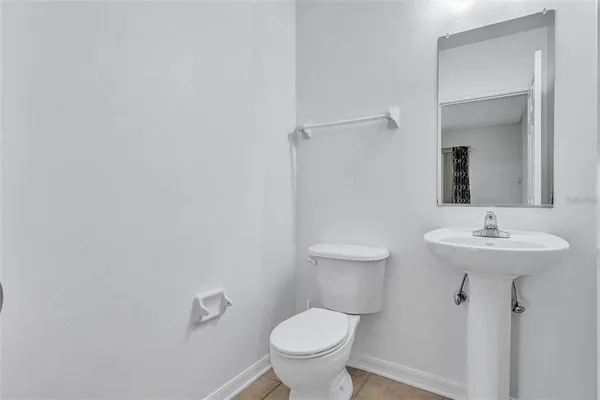 a view of staircase with white walls and white door