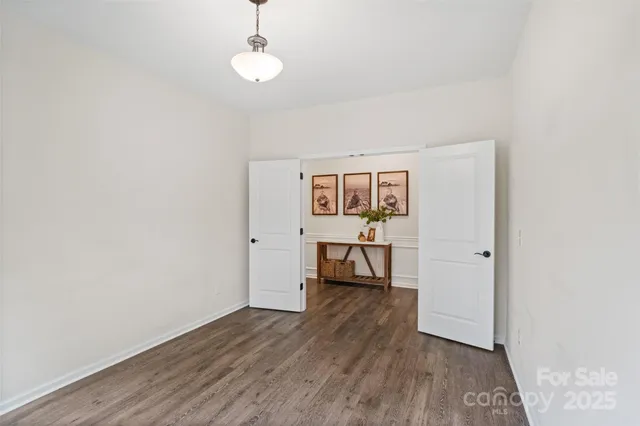 a view of a room with wooden floor a ceiling fan and window