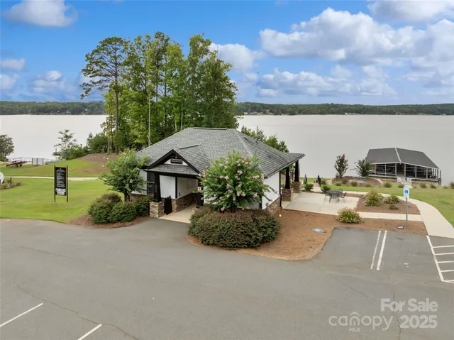 an aerial view of a house with a yard and lake