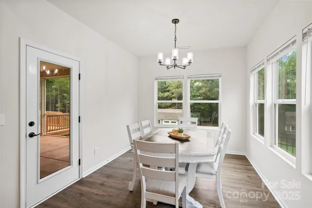 a view of a dining room with furniture a chandelier and wooden floor