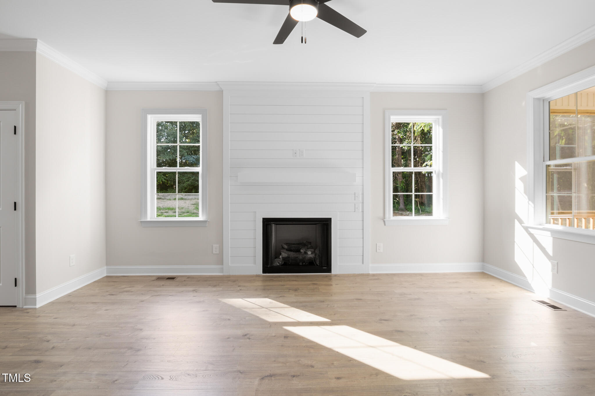 4948 Zebulon Road Zebulon, NC 27597 - Photo 10 of 35 an empty room with windows and a fireplace