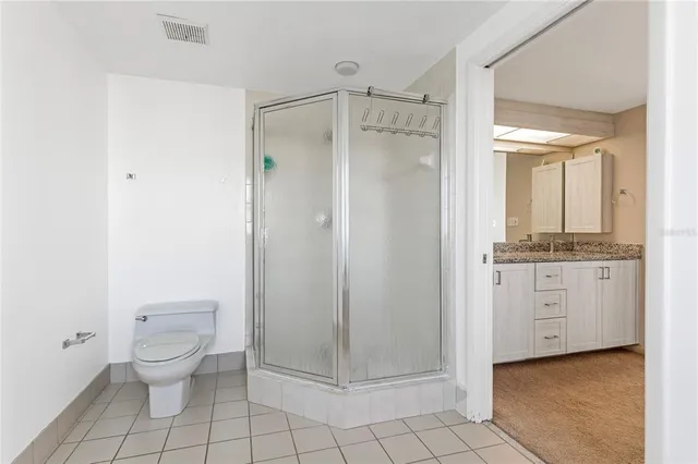 a bathroom with a granite countertop sink a toilet and a mirror