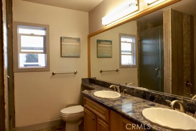 a bathroom with a granite countertop sink toilet and shower