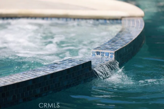 a backyard of a house with table and chairs under an umbrella