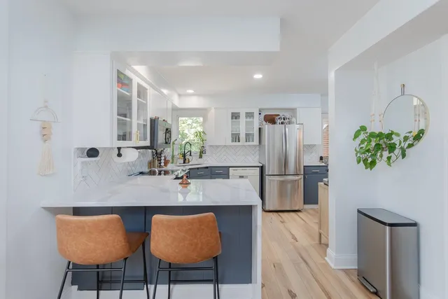 a kitchen with stainless steel appliances granite countertop a dining table chairs and granite counter tops