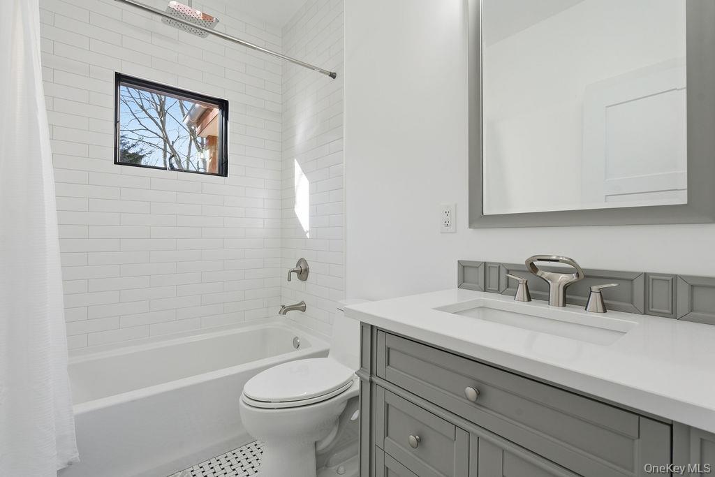768 Bridgehampton Sag Harbor Westhampton Beach, NY 11978 - Photo 10 of 35 a bathroom with a granite countertop toilet a sink a mirror and a bathtub