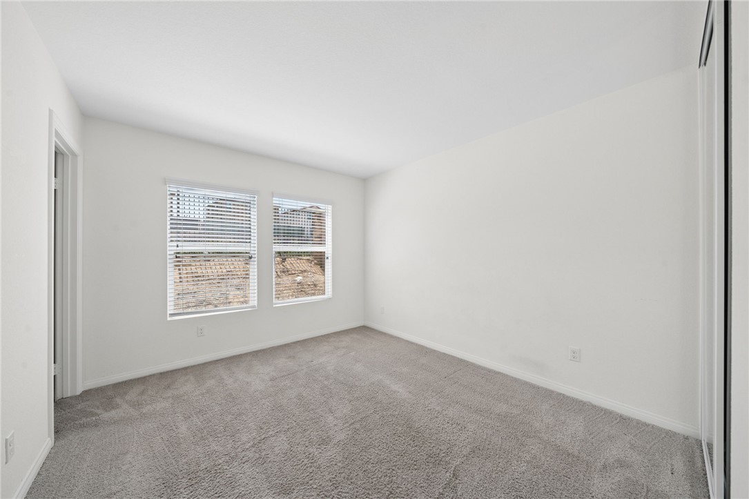 20130 Curaco Court Riverside, CA 92507 - Photo 18 of 43 Carpeted bedroom with two windows and neutral finishes.