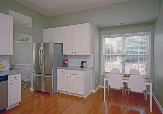 a kitchen with a table chairs refrigerator and cabinets