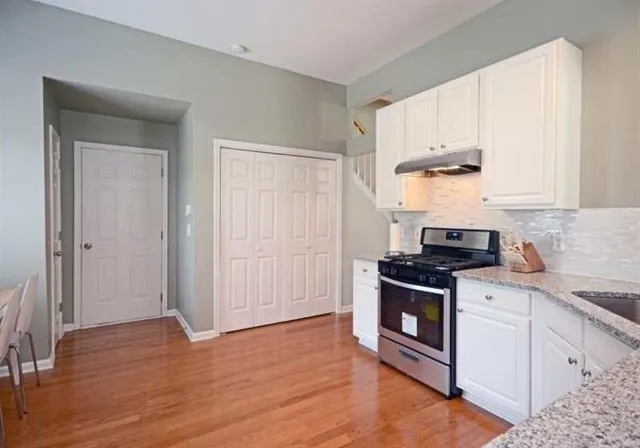 a kitchen with a stove top oven sink and cabinets