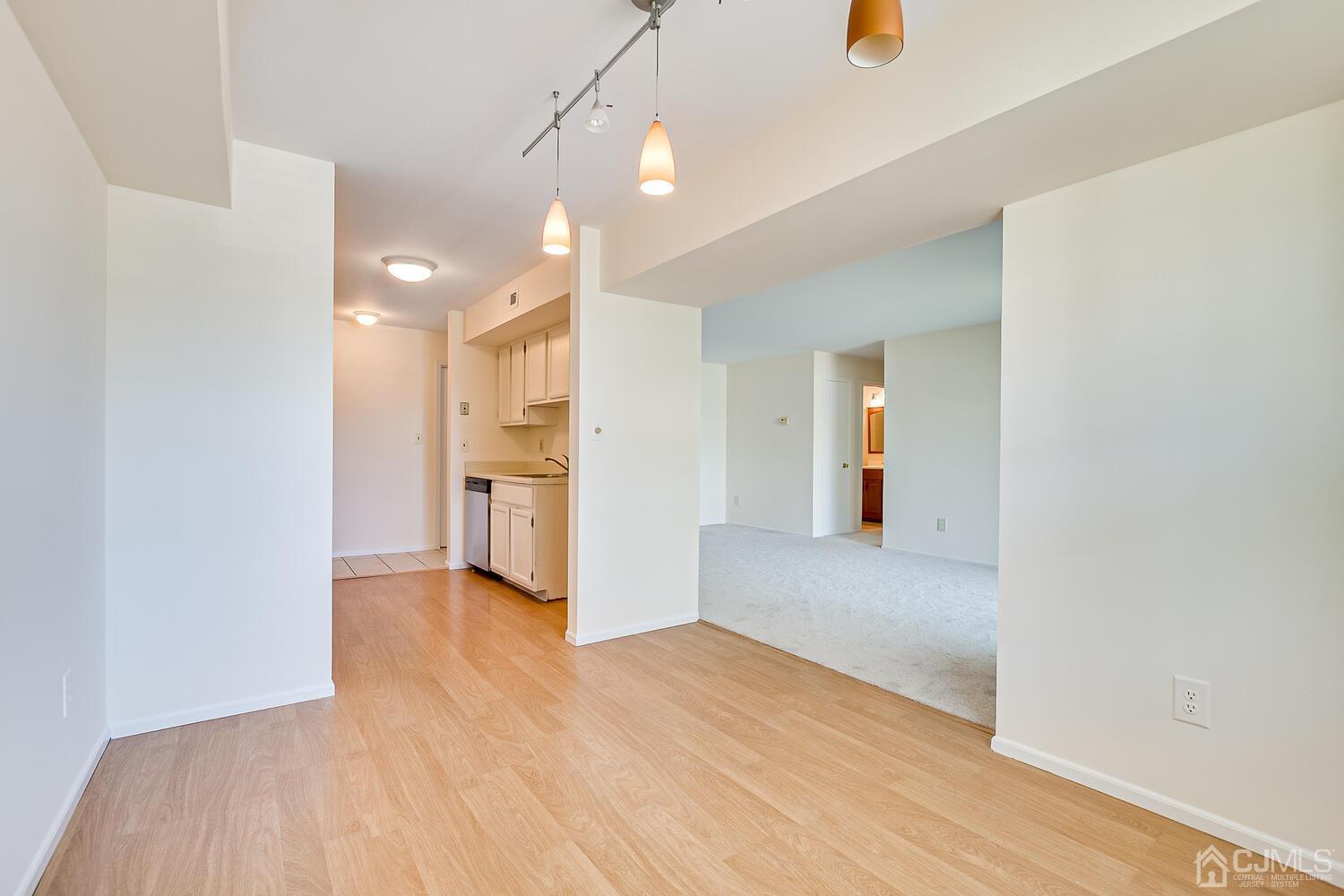 116 Keystone Court, Unit 1162 Woodbridge, NJ 07095 - Photo 12 of 28 a view of a hallway with wooden floor and a kitchen