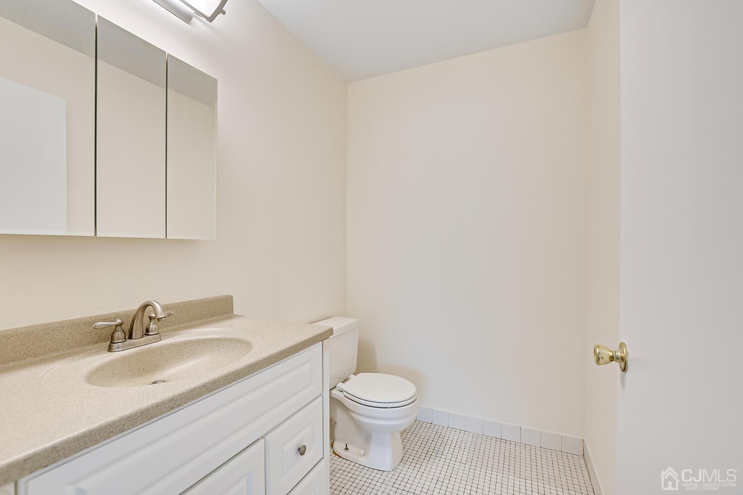 116 Keystone Court, Unit 1162 Woodbridge, NJ 07095 - Photo 21 of 28 a bathroom with a toilet sink vanity and mirror
