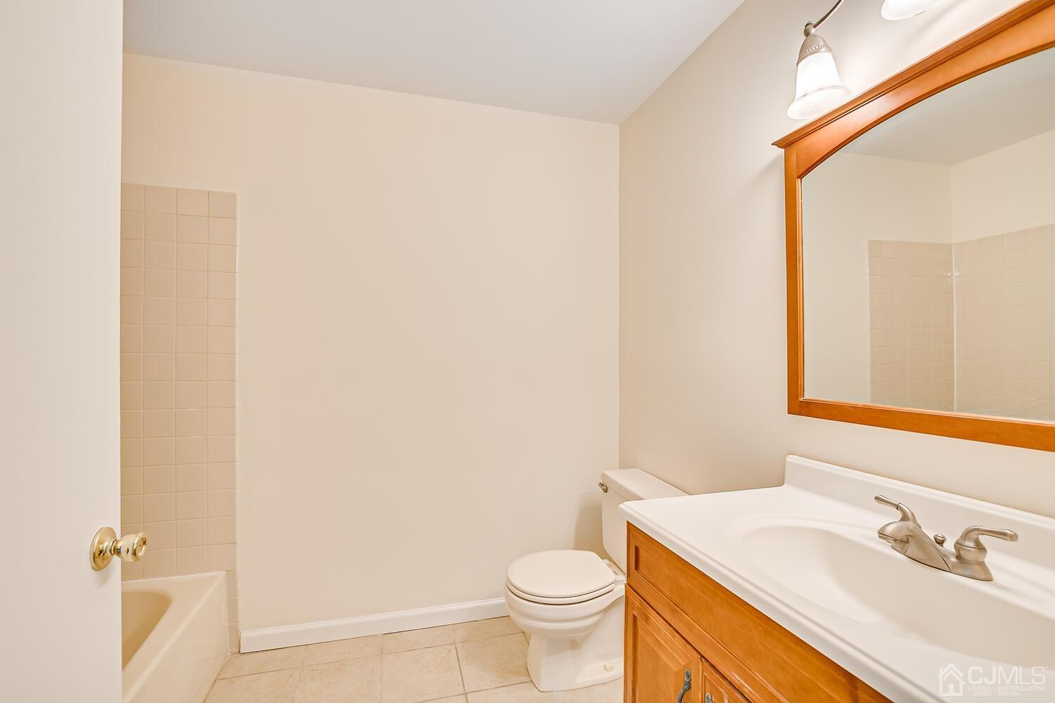 116 Keystone Court, Unit 1162 Woodbridge, NJ 07095 - Photo 25 of 28 a bathroom with a granite countertop sink toilet and a mirror