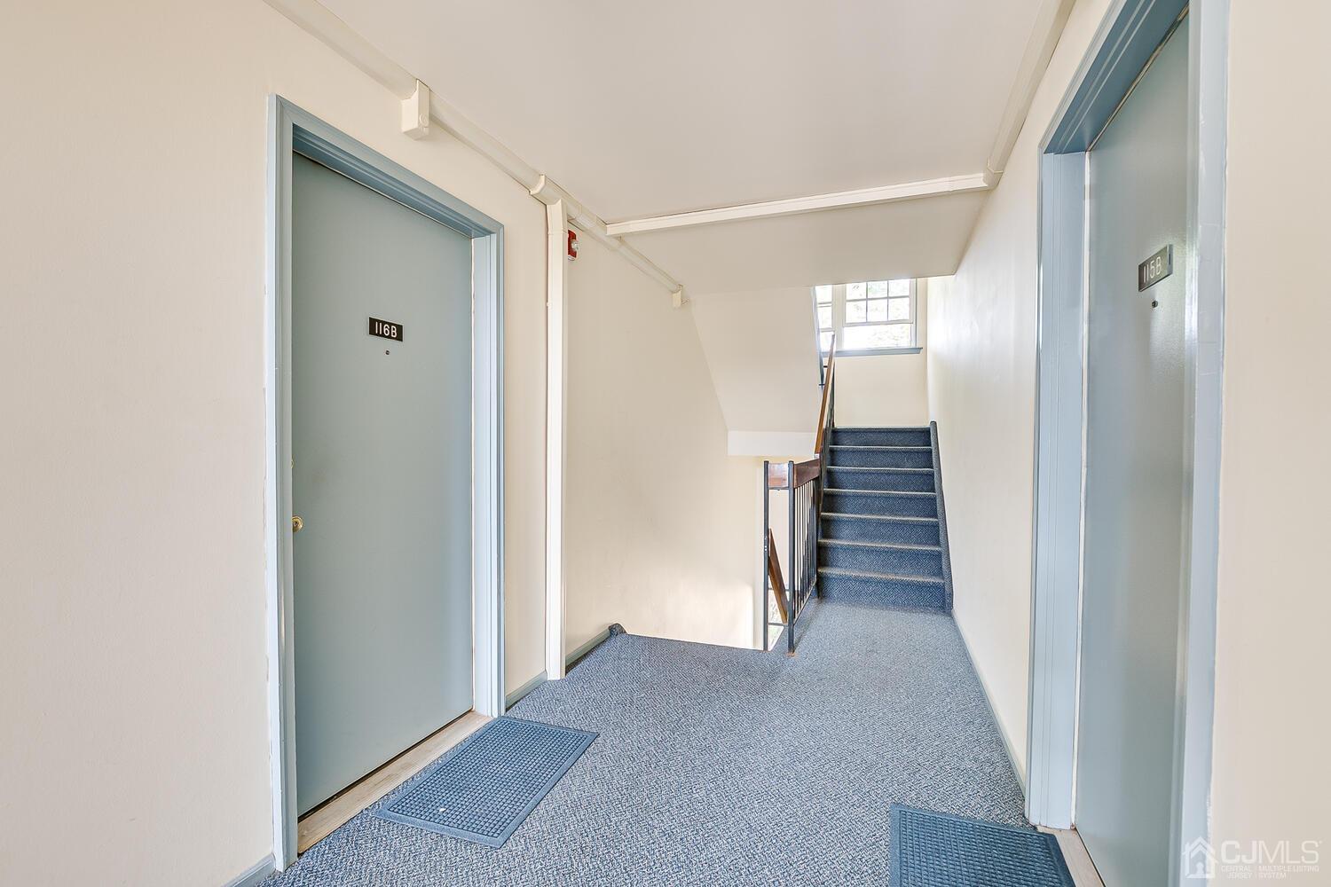 116 Keystone Court, Unit 1162 Woodbridge, NJ 07095 - Photo 4 of 28 a view of a hallway with wooden shelves