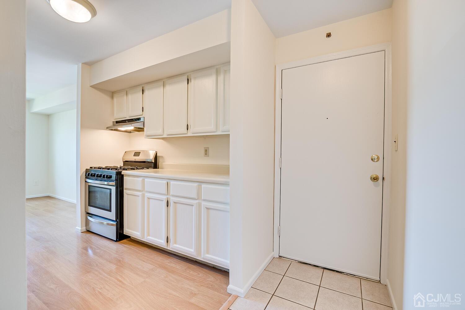 116 Keystone Court, Unit 1162 Woodbridge, NJ 07095 - Photo 6 of 28 a kitchen with white cabinets and white appliances
