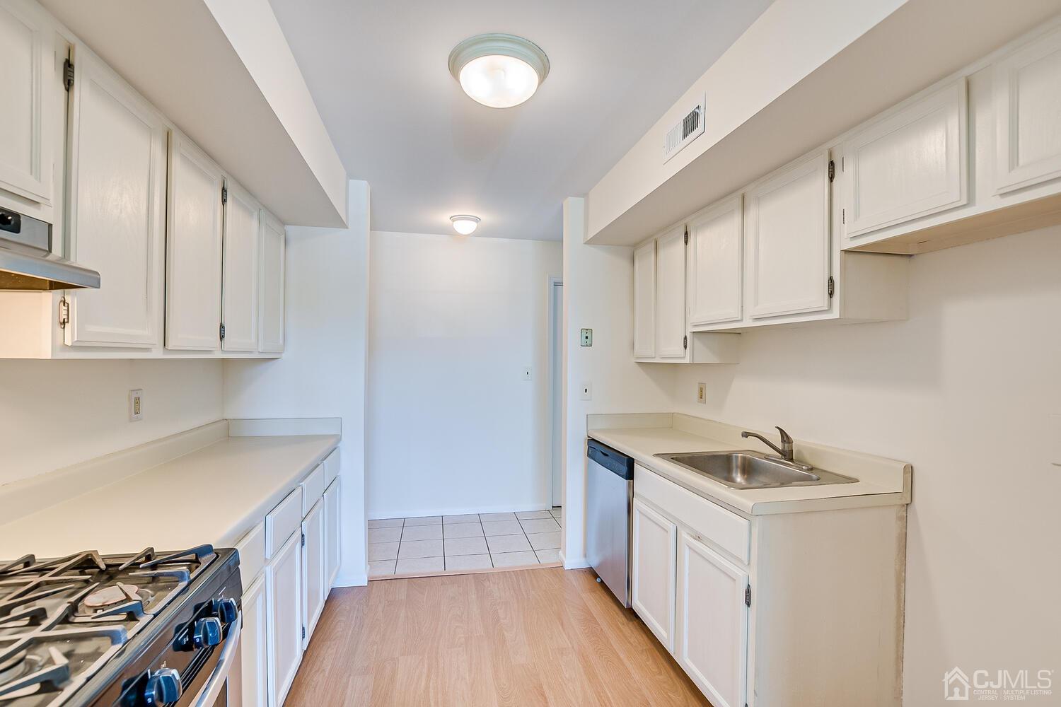 116 Keystone Court, Unit 1162 Woodbridge, NJ 07095 - Photo 7 of 28 a kitchen that has a sink and a stove in it